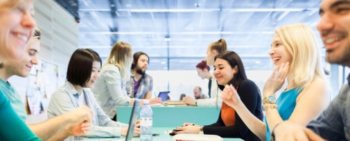 Studenter som pluggar Studenter sitter vid ett bord och pratar.