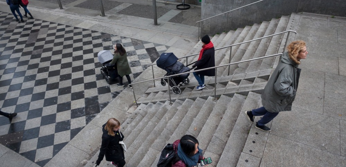 Människor som går i en grå betongtrappa.